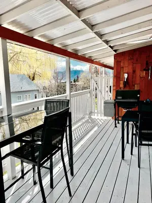 a porch with a piano and chairs on a deck at Peachland Beach Resort in Peachland