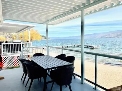 a table and chairs on a balcony with a view of the beach at Peachland Beach Resort in Peachland