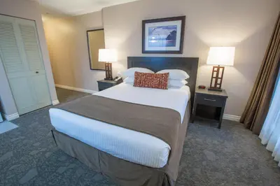 a hotel room with a bed and two lamps at The Embassy Inn in Victoria