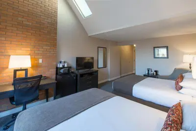 a hotel room with two beds and a desk at The Embassy Inn in Victoria