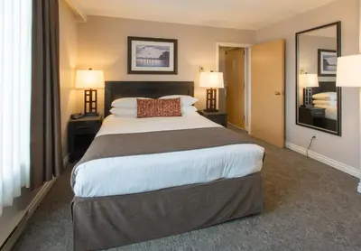 a hotel room with a large bed and two lamps at The Embassy Inn in Victoria