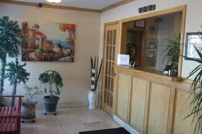 a lobby with a waiting room with plants and a door at Trailside Inn in Lloydminster