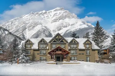 a building with a snow covered mountain in the background at Banff Inn in Banff
