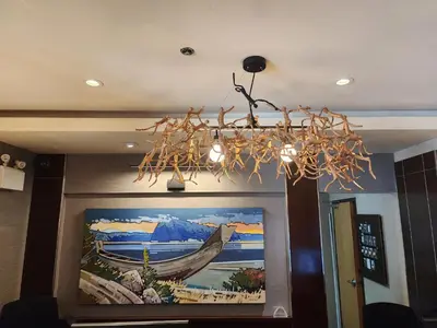 a chandelier in a room with a painting of a boat at Banff Inn in Banff