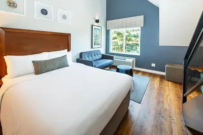 a hotel room with a bed and a chair at Banff Inn in Banff