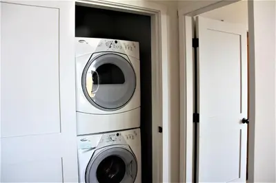two washing machines in a room next to a door at Oceanview Condo - Pacific Rim Retreat in Ucluelet