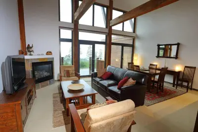 a living room with a couch and a tv at Oceanview Condo - Pacific Rim Retreat in Ucluelet