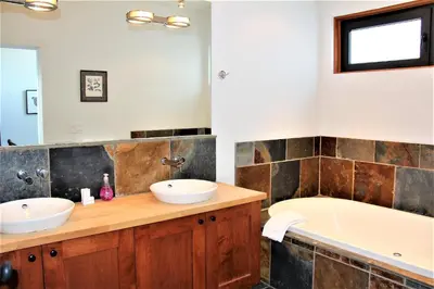 a bathroom with two sinks and a bath tub at Oceanview Condo - Pacific Rim Retreat in Ucluelet