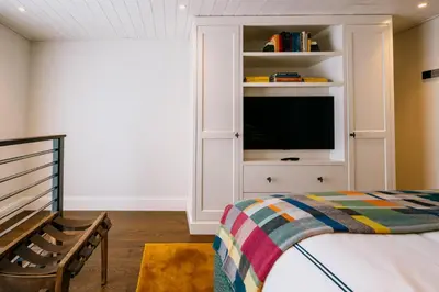a bedroom with a bed and a tv in a cabinet at Eleven Revelstoke Lodge in Revelstoke