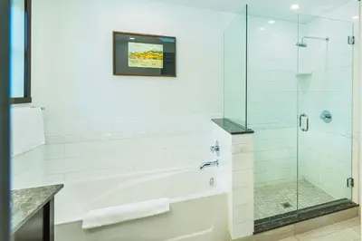 a bathroom with a glass shower and a tub at Charltons Banff in Banff
