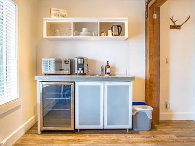 a kitchen with a counter with a sink and appliances at The Francis Boutique Inn in Ucluelet