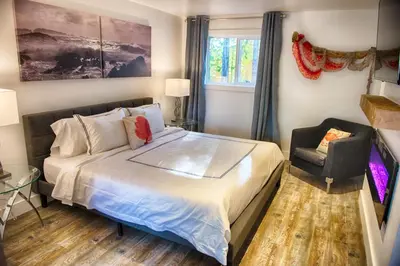 a bedroom with a bed and a chair at The Francis Boutique Inn in Ucluelet