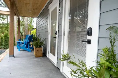 a screened porch with blue chairs on a house at The Francis Boutique Inn in Ucluelet