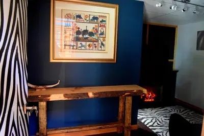 a blue room with a wooden table and a picture at South Africa House Guest Lodge in Wainwright
