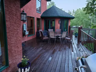 a wooden deck with a table and chairs on a house at South Africa House Guest Lodge in Wainwright