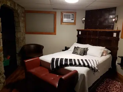 a bedroom with a bed and a leather chair at South Africa House Guest Lodge in Wainwright