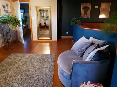 a blue couch sitting in a living room at South Africa House Guest Lodge in Wainwright