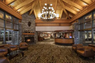 a hotel lobby with a fireplace and a chandelier at Royal Canadian Lodge in Banff
