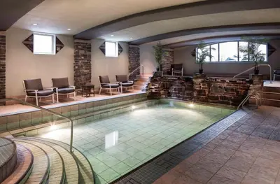 a lap pool in a hotel with chairs and tables at Royal Canadian Lodge in Banff