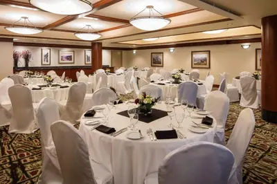 a banquet room with white tables and white chairs at Royal Canadian Lodge in Banff