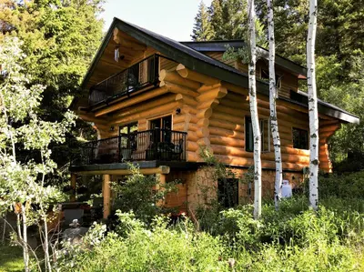 a log cabin in the woods with a balcony at A Suite Retreat - Beyond Bed & Breakfast in Sun Peaks