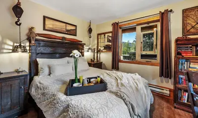 a bedroom with a bed with a wooden head board at A Suite Retreat - Beyond Bed & Breakfast in Sun Peaks