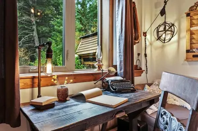 an office with a wooden desk with a window at A Suite Retreat - Beyond Bed & Breakfast in Sun Peaks