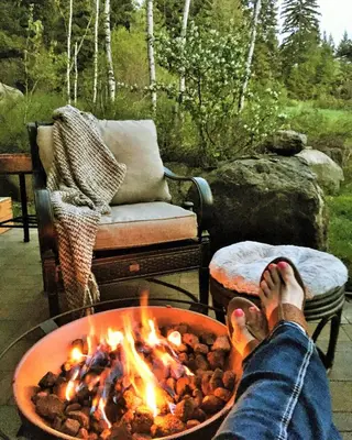 a person sitting in front of a fire pit at A Suite Retreat - Beyond Bed & Breakfast in Sun Peaks