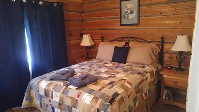 a bedroom with a bed in a log cabin at Wolfwood Guest Ranch in Clearwater