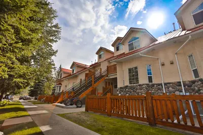 a house with a wooden fence in front of it at Riverside by StayIn in Fernie