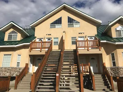 a large house with stairs leading up to it at Riverside by StayIn in Fernie