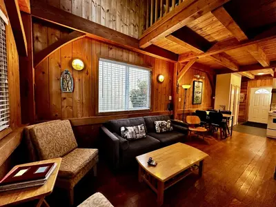 a living room with a couch and a table at Waterfront Timber-Frame Cottage! in Ucluelet
