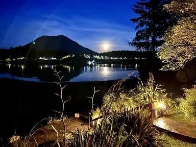 a view of a lake at night with a mountain at Private Oceanfront Cabin With Hot Tub Doc Holiday Cabin in Ucluelet