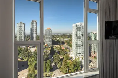 a room with three windows with a view of a city at Civic Hotel, Autograph Collection in Surrey