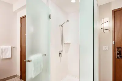 a bathroom with a shower with a glass door at Civic Hotel, Autograph Collection in Surrey