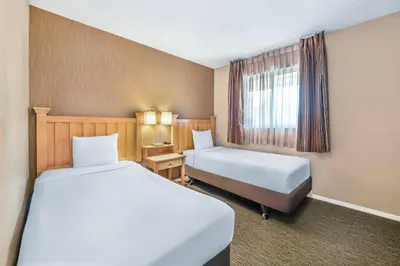 a hotel room with two beds and a window at Econo Lodge Inn & Suites in North Vancouver