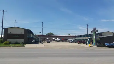 an empty parking lot next to a building with a street at RANCHLAND Inn in Nanton