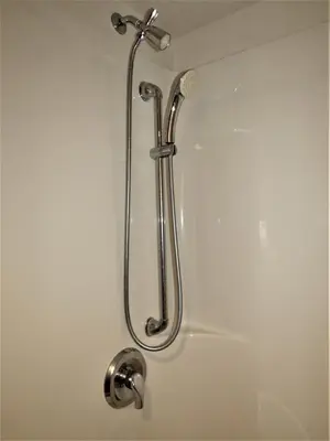 a shower with a shower head in a bathroom at RANCHLAND Inn in Nanton