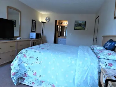 a bedroom with a bed with a blue comforter at RANCHLAND Inn in Nanton
