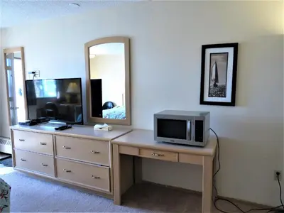 a living room with a television and a mirror at RANCHLAND Inn in Nanton