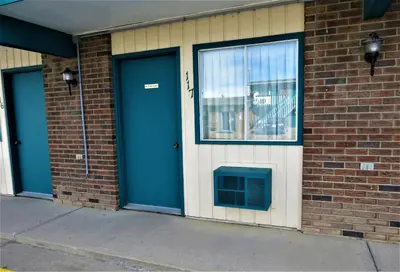 a brick building with blue doors and a window at RANCHLAND Inn in Nanton