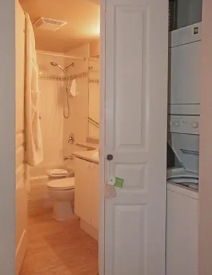 a bathroom with a toilet and a sink at Times Square Suites Hotel in Vancouver