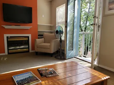a living room with a fireplace and a tv at Times Square Suites Hotel in Vancouver