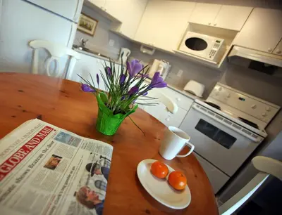 a table with a newspaper and a vase with eggs and flowers at Times Square Suites Hotel in Vancouver