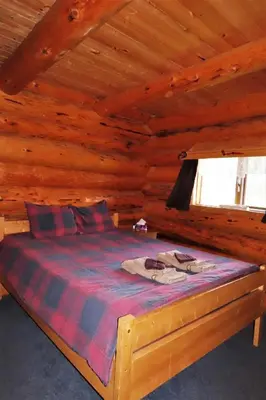 a bedroom with a bed in a log cabin at Rocky Ridge Resort-BC in Smithers
