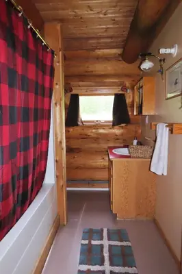 a bathroom in a log cabin with a sink at Rocky Ridge Resort-BC in Smithers