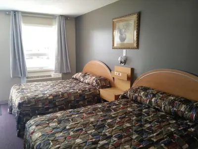a hotel room with two beds and a window at Aries Motel in Edson