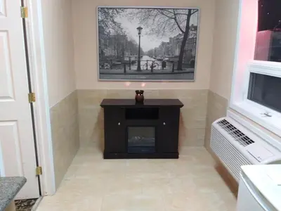 a living room with a fireplace and a picture on the wall at Aries Motel in Edson