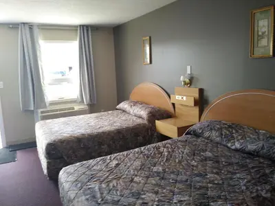a hotel room with two beds and a window at Aries Motel in Edson