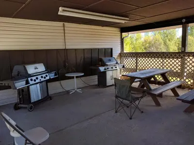 a patio with a table and a grill and a picnic table at Mountain Edge our Holiday Home in Kimberley